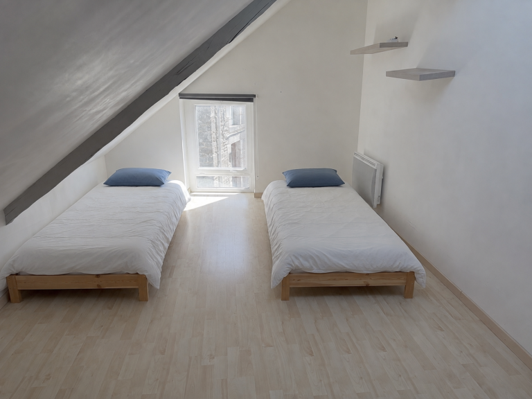 Chambre mansardée avec deux lits simples